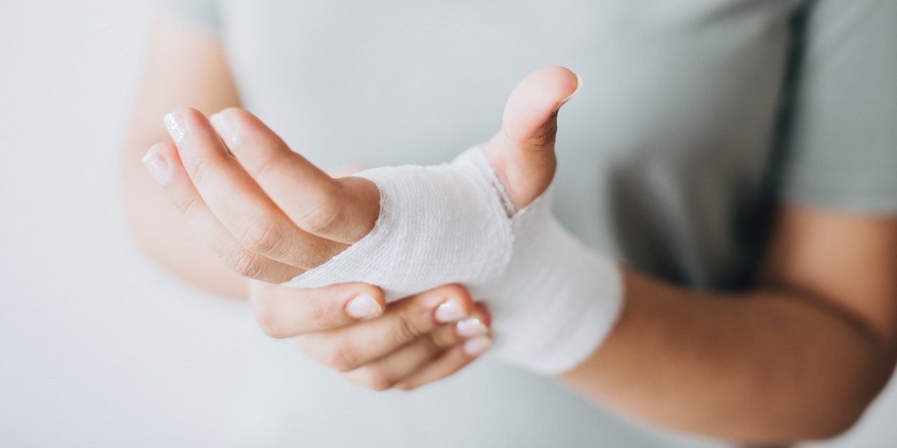 woman-holding-bandaged-hand-after-injury